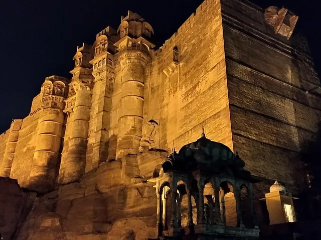 A low-angle view of Mehrangarh Fort illuminated at night