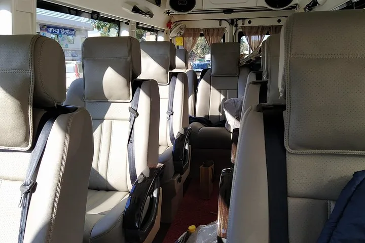 The interior of a tour van with rows of beige leather seats